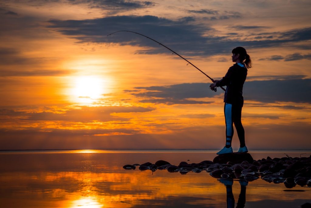 Woman fishing on Fishing rod spinning in Norway.